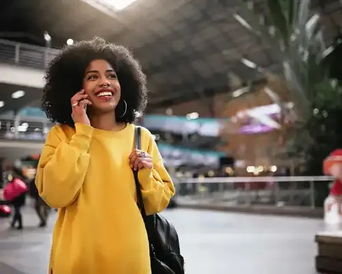 travel-insurance-for-a-beautiful-afro-woman-using-mobile-in-the-train-station