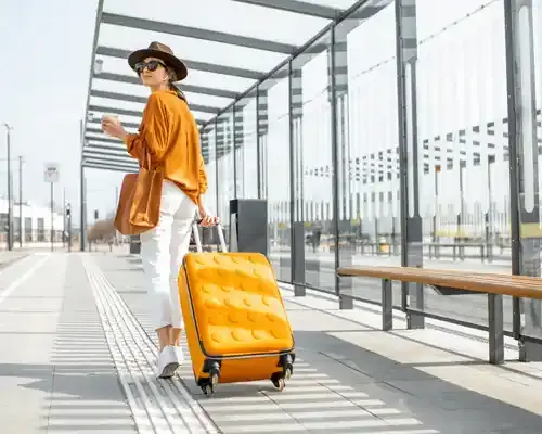 travel-insurance-for-a-young-female-traveler-walking-with-a-yellow-suitcase-at-the