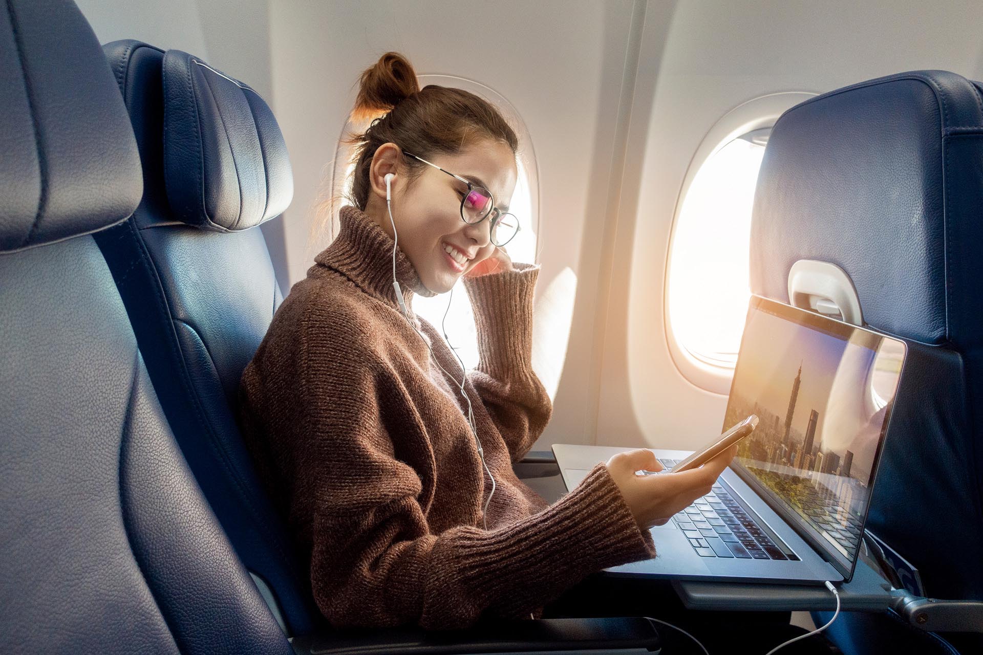 beautiful-asian-woman-is-working-with-laptop-in-airplane