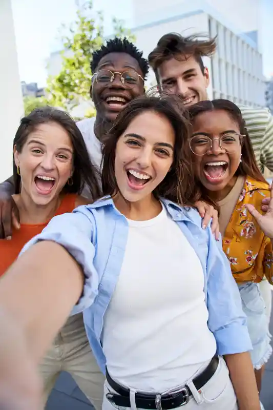 vertical-selfie-young-excited-friends-looking-at-camera-happy-smiling